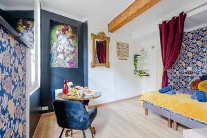 una camera con un letto e un tavolo con cibo sopra di Le Romantique - Place St Didier - Cœur de ville ad Avignone