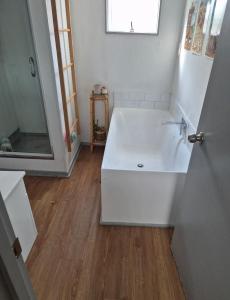 un bagno bianco con vasca e specchio di Aurora A-Frame Twizel a Twizel