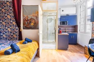 una camera da letto con un letto con cuscini blu di Le Romantique - Place St Didier - Cœur de ville ad Avignone Altre 22 foto