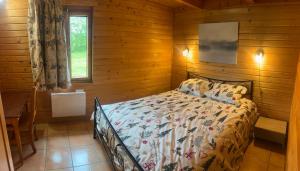 Un dormitorio con una cama en una cabaña de troncos en Chalet de l empereur, en Ussel