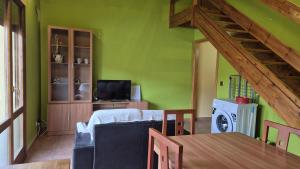 Murillo de LienaCasa Juanantonio的客厅设有绿色的墙壁、一张沙发和一张桌子