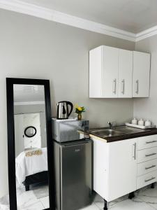 4 at Granada في شرق لندن: مطبخ مع حوض ودواليب بيضاء