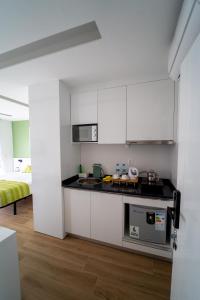 a kitchen with white cabinets and a counter top at GREEN STUDIO - Apt 003 Aconchegante e Moderno in Tarrafal