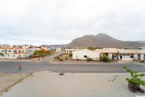 an empty street in a small town with a mountain at GREEN STUDIO - Apt 003 Aconchegante e Moderno in Tarrafal