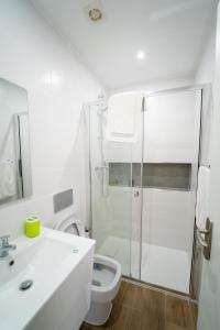 a white bathroom with a shower and a toilet at GREEN STUDIO - Apt 003 Aconchegante e Moderno in Tarrafal