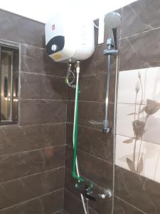 a shower with a blow dryer on a wall at Deluxe Twin Beds in Royal Blue Guest House and Bar Lome in Lomé