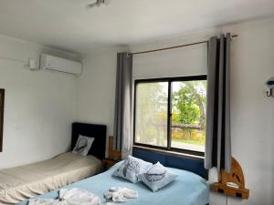 due letti in una stanza con finestra di Pousada La Marea a Rio Grande