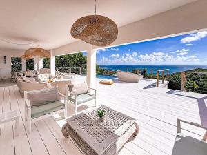 a house with a deck with a view of the ocean at Villa Atao, sublime view of Orient Bay and the islands in Cul de Sac +41 photos