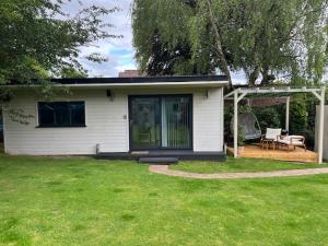 ein kleines weißes Haus mit einer Veranda und einer Terrasse in der Unterkunft Independent garden studio - sleeps max 3. in Derby