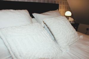 two white pillows sitting on top of a bed at Chambre d'hôtes cosy à la campagne in Bourg-des-Comptes