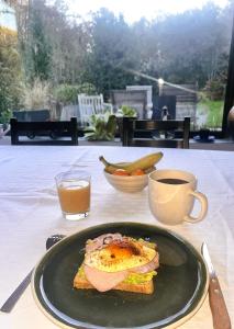 un panino su un piatto su un tavolo con una tazza di caffè di Chambre d'hôtes cosy à la campagne a Bourg-des-Comptes