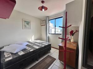 Un dormitorio pequeño con una cama y una ventana. en B362 - Cobertura a poucos passos do mar com piscina privativa., en Bombas 29 fotos más