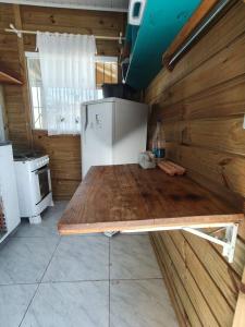 a kitchen with a wooden table and a refrigerator at Casa Praia in Piçarras