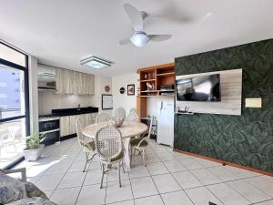 Una cocina y un comedor con mesa y sillas. en B362 - Cobertura a poucos passos do mar com piscina privativa., en Bombas