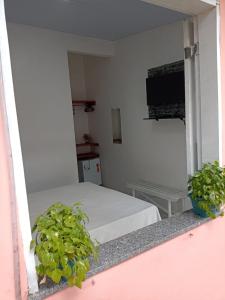 Habitación con cama y TV. en Pousada Jatobá, en Barreirinhas