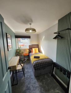 Urban 4BR house - Central-FREE parking-NO PARTY في غلاسكو: غرفة نوم بها سرير وطاولة ومكتب +20 صورة