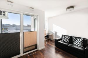 Una sala de estar con un sofá y una ventana grande. en Apartamenty Platinex 5, en Cracovia