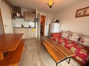 a living room with a couch and a wooden table at apptT2 station ski familiale in Thollon