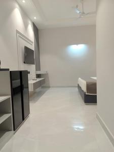 a white room with a bed and a white tile floor at JBM resort & hotel in Jāmb