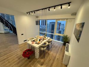 Exclusive Penthouse And SPA في ريغا: غرفة طعام مع طاولة وكراسي ونافذة كبيرة