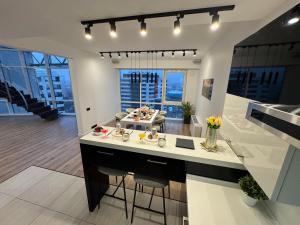 Exclusive Penthouse And SPA في ريغا: مطبخ مع كاونترات بيضاء وغرفة معيشة