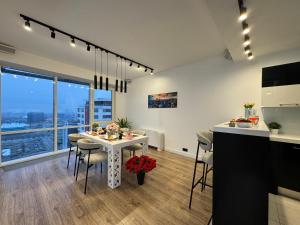 Exclusive Penthouse And SPA في ريغا: مطبخ وغرفة طعام مع طاولة وكراسي