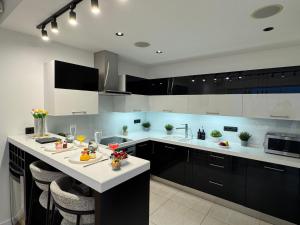 Exclusive Penthouse And SPA في ريغا: مطبخ مع خزائن سوداء وقمم منضدة بيضاء +17 صورة