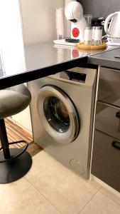 a washing machine in a kitchen under a counter at Luxury studio Perun Lodge in Bansko