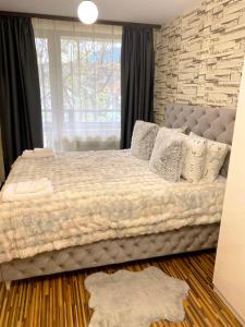 a bedroom with a large bed in front of a window at Luxury studio Perun Lodge in Bansko