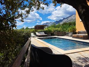 PuyloubierMaison d'hôtes la Garenne的一个带桌椅和山脉的游泳池