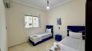 非斯Appart Hotel Fes - Joud Families & Travelers的有两张床和一扇窗户的小房间