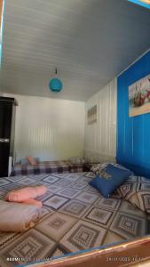 ein Schlafzimmer mit zwei Betten und einer blauen Decke in der Unterkunft Cabanas LA CASITA BRISA DO MAR in Navegantes