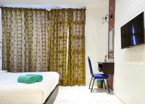 una habitación con una cama y una silla y un televisor en Hotel Double Star Klia, en Sepang