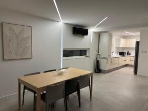 a dining room with a table and chairs and a kitchen at Le Cube Strasbourg - Marlenheim in Marlenheim