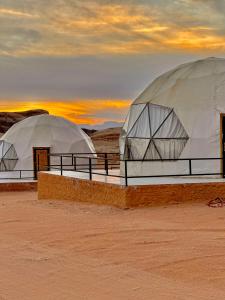ワディ・ラムにあるWADI RuM GRANDの夕日を背景にした砂漠の2つのドーム