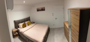 a small bedroom with a bed with yellow pillows at Le Cube Strasbourg - Marlenheim in Marlenheim