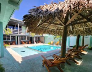 ベラクルスにあるMas Basico Hotelの椅子とパラソルのあるプールとスイミングプール