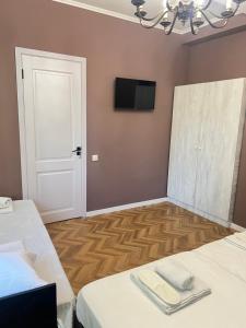 a room with two beds and a flat screen tv at Hotel maisis ezo in Kutaisi
