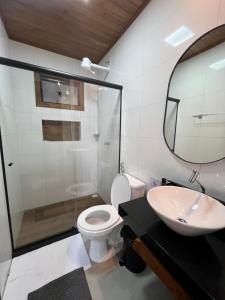 a bathroom with a toilet and a sink and a mirror at Sítio Rancho Mineiro in Domingos Martins +15 photos