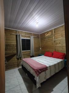 a bedroom with a bed with red pillows at Casa Praia in Piçarras