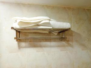 a pile of towels sitting on a shelf in a bathroom at Best Eastern Apartments - With Balcony & Kitchen in Dhaka +32 photos