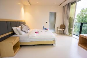 a bedroom with a bed and a large window at Aqua Luna Dhangethi in Dhangethi