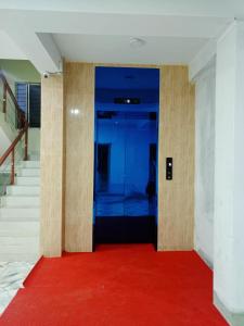 a hallway with a red carpet and a blue door at Best Eastern Apartments - With Balcony & Kitchen in Dhaka