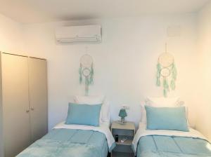 2 Betten in einem blau-weißen Zimmer in der Unterkunft Écija Confort by Casa Yaye in Écija