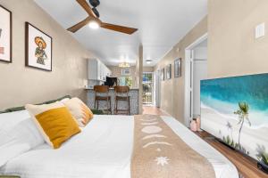 a bedroom with a large bed and a tv at Casa Aloha Designer Condo w Oceanfront Pool in Kailua-Kona +30 photos