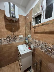 a bathroom with a sink and a tv on the wall at Islamabad Apartment in Islamabad