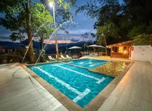 a swimming pool in front of a house at Ecohotel Alflo Inn in Villeta