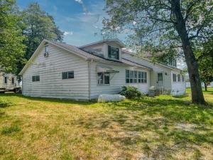 ein weißes Haus mit einem Baum im Hof in der Unterkunft Boho Waterfront Getaway 5 Bedroom Retreat in Solomons
