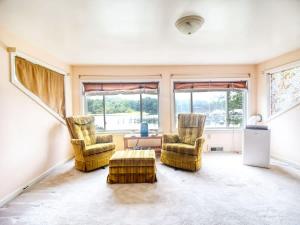 ein Wohnzimmer mit zwei Stühlen und einem Tisch in der Unterkunft Boho Waterfront Getaway 5 Bedroom Retreat in Solomons + 21 Fotos