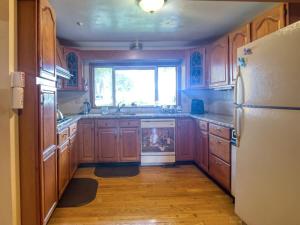 eine Küche mit Holzschränken und einem weißen Kühlschrank in der Unterkunft Boho Waterfront Getaway 5 Bedroom Retreat in Solomons